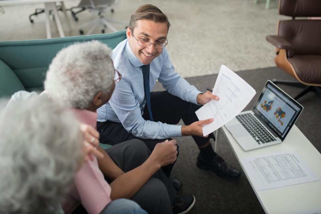pexels-photo-8441811-8441811 Financial advisor discussing documents with senior clients in an office setting, showcasing a collaborative consulting session.